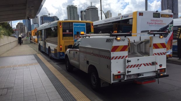 Crews work to clear a broken-down bus at the Cultural Centre bus station.