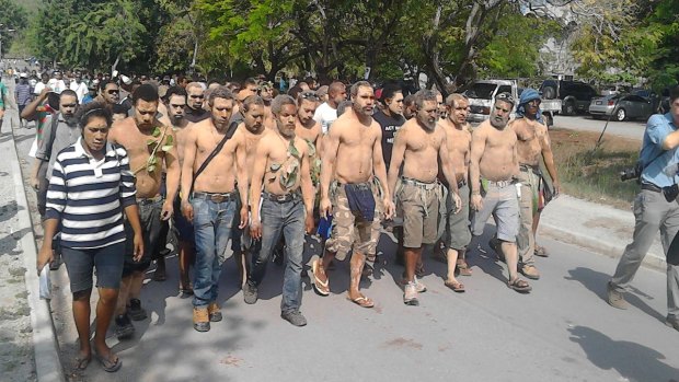 Students in Papua New Guinea march to campus with mud on their bodies as a symbol of mourning after police last week shot protesters at the university.