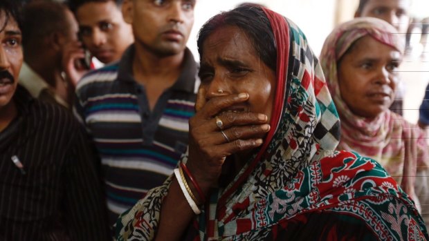 A relative of a fire victim cries as victims' bodies are carried into a makeshift morgue at a hospital after the fire broke out.