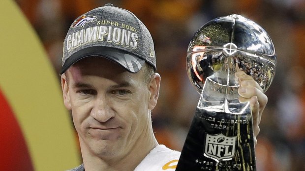 Peyton Manning holds up the trophy.