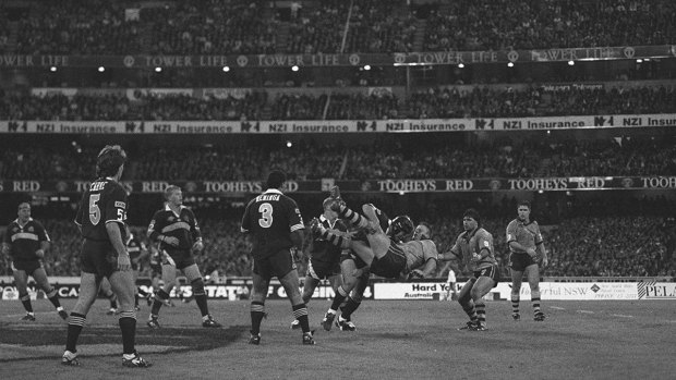 Full house: Queensland's Darren Smith upends Blues prop Glenn Lazarus at the MCG in 1994.