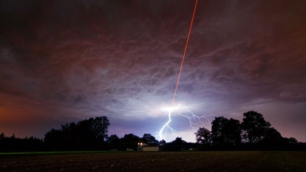 A laser-guided telescope is tested at the Allgau Public Observatory in Bavaria, Germany. Two astronomers at Columbia University believe lasers could be used to disguise Earth from aliens.
