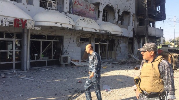 Iraqi security forces inspect one of the damaged buildings after clashes between Iraqi security forces and members of the Islamic state in the city of Kirkuk on October 22. 