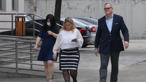 Crown employee Jenny Jiang (wearing a mask) and her husband Jeff Sikkema walking out of Baoshan People's Court in Shanghai in June.