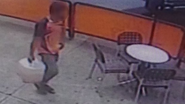 CCTV footage showing a man walking back to the bank with a container after he visited a service station. 