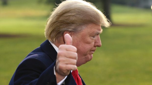 President Donald Trump gives a thumbs up after speaking to reporters.