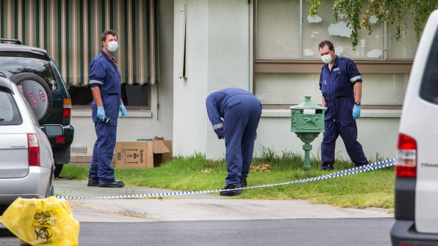 Police at the home where a woman's body was discovered.