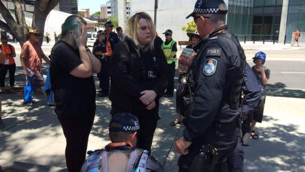 Police speak to a woman after the discovery of a gas mask and a knife at a G20 protest.