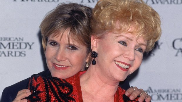 Actress Carrie Fisher hugging her mother, entertainer Debbie Reynolds, at the American Comedy Awards. 