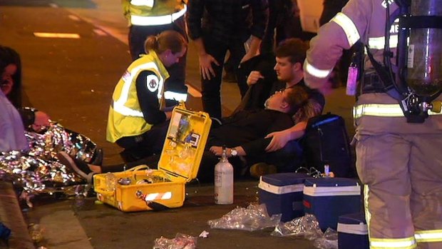 Paramedics treat patrons on the street after a mystery gas was released inside the Perseverance bar.