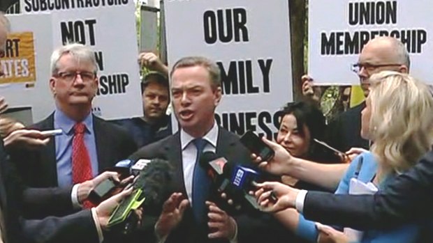 Christopher Pyne speaks to media in Adelaide on Wednesday, surrounded by protesters.