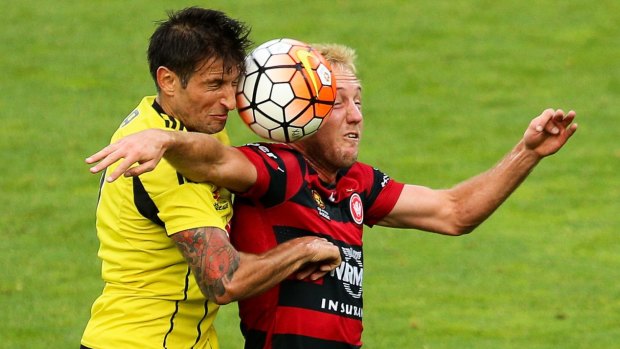 Close encounter: Vince Lia of the Phoenix and Mitch Nichols of the Wanderers compete for the ball.
