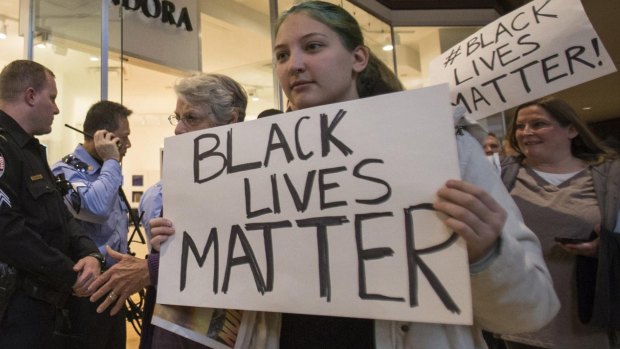Shutting shops: Protesters, demanding justice for the killing of 18-year-old Michael Brown, interrupt Black Friday shopping while marching through the St Louis Galleria Mall in Missouri. 