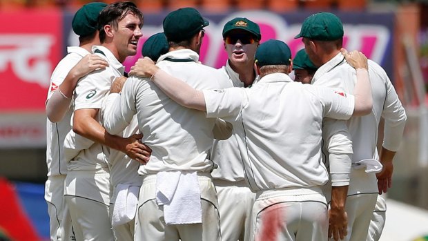 Pat Cummins is congratulated by his teammates after claiming the scalp of India's captain Virat Kohli on day three of the third Test in Ranchi.