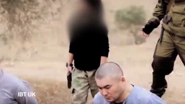 A screenshot from a new video posted online by Islamic State that purports to show a child executing two hostages.