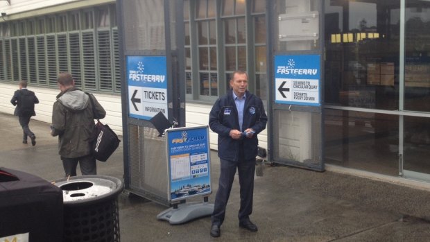 Stiff competition: Former prime minister Tony Abbott chasing the commuter vote at Manly wharf.