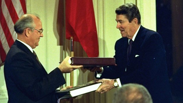 Then US President Ronald Reagan and Soviet leader Mikhail Gorbachev exchange copies of a treaty to eliminate intermediate-range missiles during a signing ceremony at the White House on December 8, 1987.