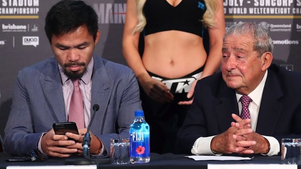 Obsession: Manny Pacquiao taps away on his phone during a press conference for the Brisbane fight. 