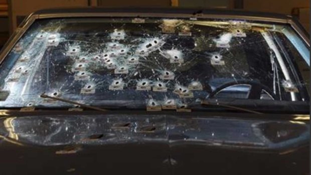 In this November 30, 2012 file forensics photo, bullet holes are visible on the windshield and bonnet of a Chevy Malibu peppered by gunshots after a high-speed chase that ended in the deaths of two unarmed suspects.