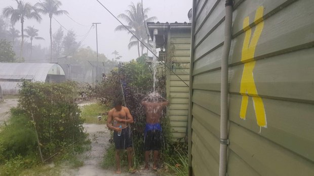 Men inside the now-closed regional processing centre at Manus Island, purportedly showering in the rain.