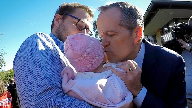Shorten kisses a baby after an announcement on Labor's gender equality policies at the Smith Park Kingsgrove Community Centre earlier this year.