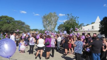 Mourners release purple balloons in memory of Talieha.