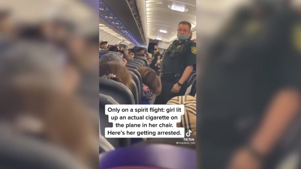 US deputies approach a plane passenger on a Spirit Airlines flight after she lit up a cigarette.