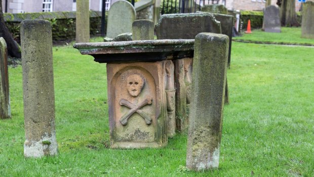 A tombstone in the church yard of the Parish Church of St Lawrence in the 'plague village' of Eyam, Derbyshire.