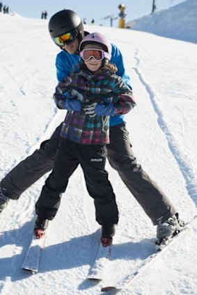 Dad helping daughter on the beginner slopes.
