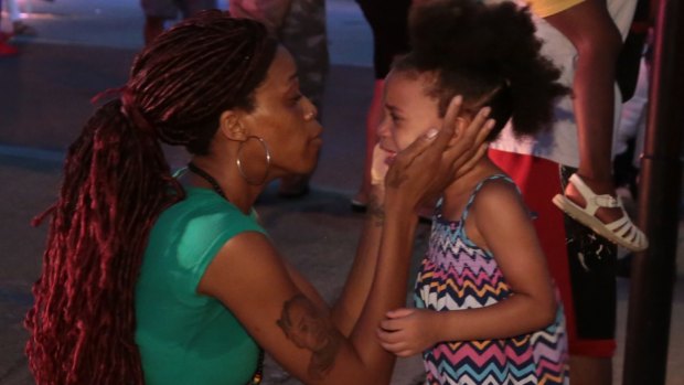 A mother tries to calm her daughter as Dallas police respond to the police shootings on Thursday.