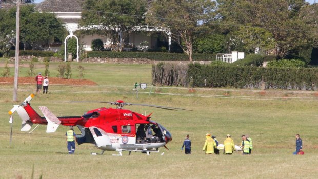 An injured boy is carried to an Ambulance helicopter following the crash.