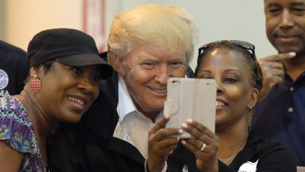 President Donald Trump poses for selfies at the hurricane relief centre.
