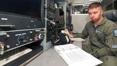 US Air Force Captain Cory Kuehn, with the 625th Strategic Operations Squadron, reads his technical order booklet in front of the Airborne Launch Control System procedures trainer on Offutt Air Force Base, Nebraska.