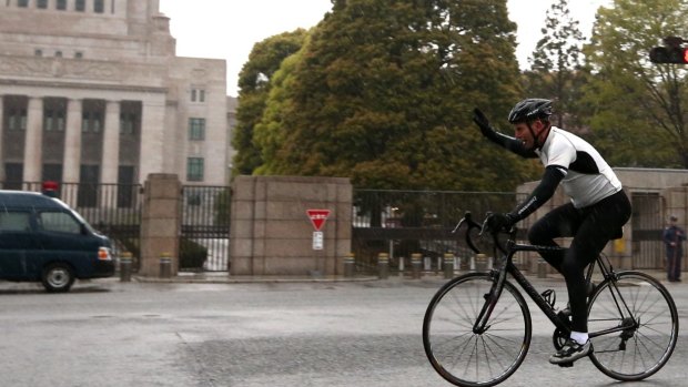 Prime Minister Tony Abbott on an early morning bike ride past the National Diet Building in Tokyo last year. A cycling present from the Japanese prime minister was the most expensive gift Mr Abbott will keep from his time as national leader.