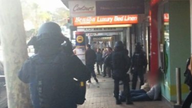 Swoop: Police take the two suspects in Neutral Bay.
