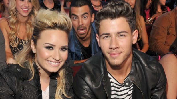 Musicians Demi Lovato, Joe Jonas, and Nick Jonas attend the 2013 Teen Choice Awards. The three are friends working to raise awareness of mental health.