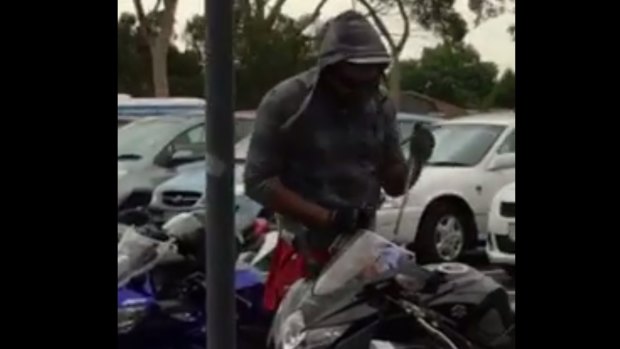 A screenshot of a masked man stealing a motorbike at RMIT's Bundoora campus.