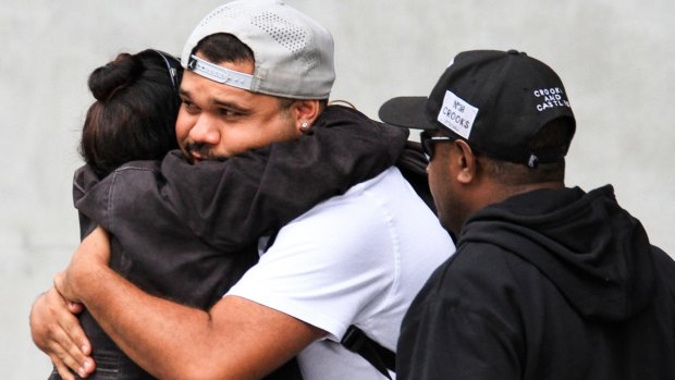Lewis Warria hugs a supporter after leaving a Mental Health Court hearing into the deaths of seven of his siblings at the hands of his mother, Raina Thaiday.