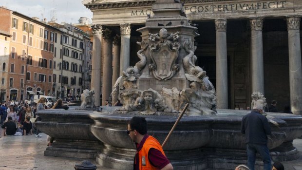 A street cleaner sweeps around the Fountain of the Pantheon in downtown Rome, on Tuesday.