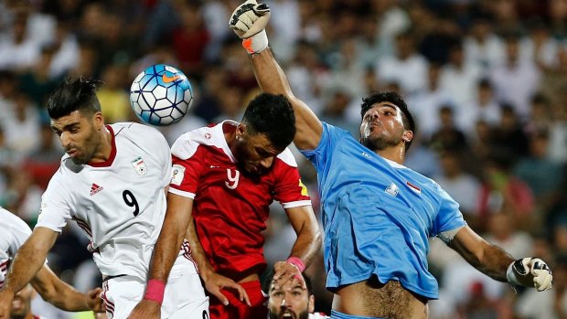 Omar Al-Soma, in red, flies in for a header against Iran.