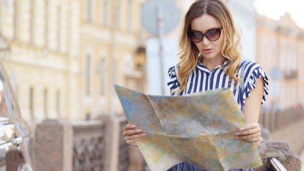 A tourist grapples with an old-school map.