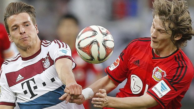 Bayern's Lukas Goertler, left, and Leverkusen's Tin Jedvaj challenge for the ball.