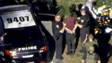 A still image in video from WSVN.com shows a man, named as Nikolas Cruz, being placed in handcuffs bypolice near Marjory Stoneman Douglas High School.
