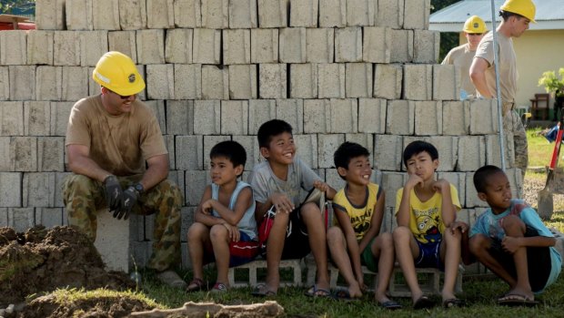 Australian Army Sapper Joshua Park takes a break from construction to spend time with Filipino children during Balikatan 2017 in Ormoc City, Leyte.