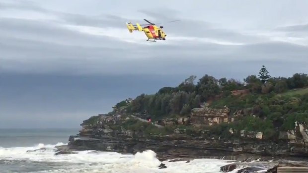 The Westpac Rescue Helicopter searches for a person missing in heavy surf south of Bondi Icebergs.