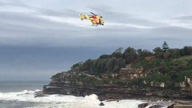 The Westpac Rescue Helicopter searches for a person missing in heavy surf south of Bondi Icebergs.
