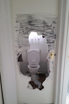 A giant hole smashed in the door to the toilet at the Kambah house.