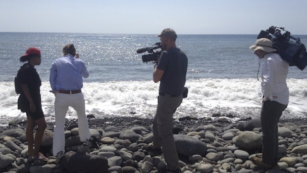 Betty, left, shows reporters the spot where a small piece of metal was found on a beach in Saint-Denis.