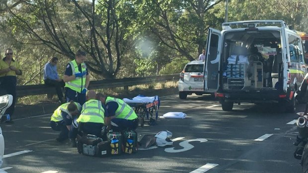 Paramedics treat the injured motorcyclist on the freeway.