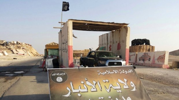 A sign is posted at a checkpoint belonging to IS at the main entrance of Rawah in July 2014. It reads:  "Islamic State, the Emirate of Anbar, City of Rawah."